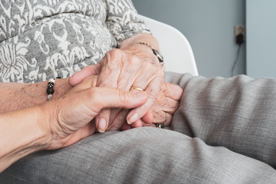 daughter holds her elderly mother's hand